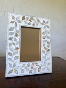 Small mirror with pearl inlay detail in flower pattern.